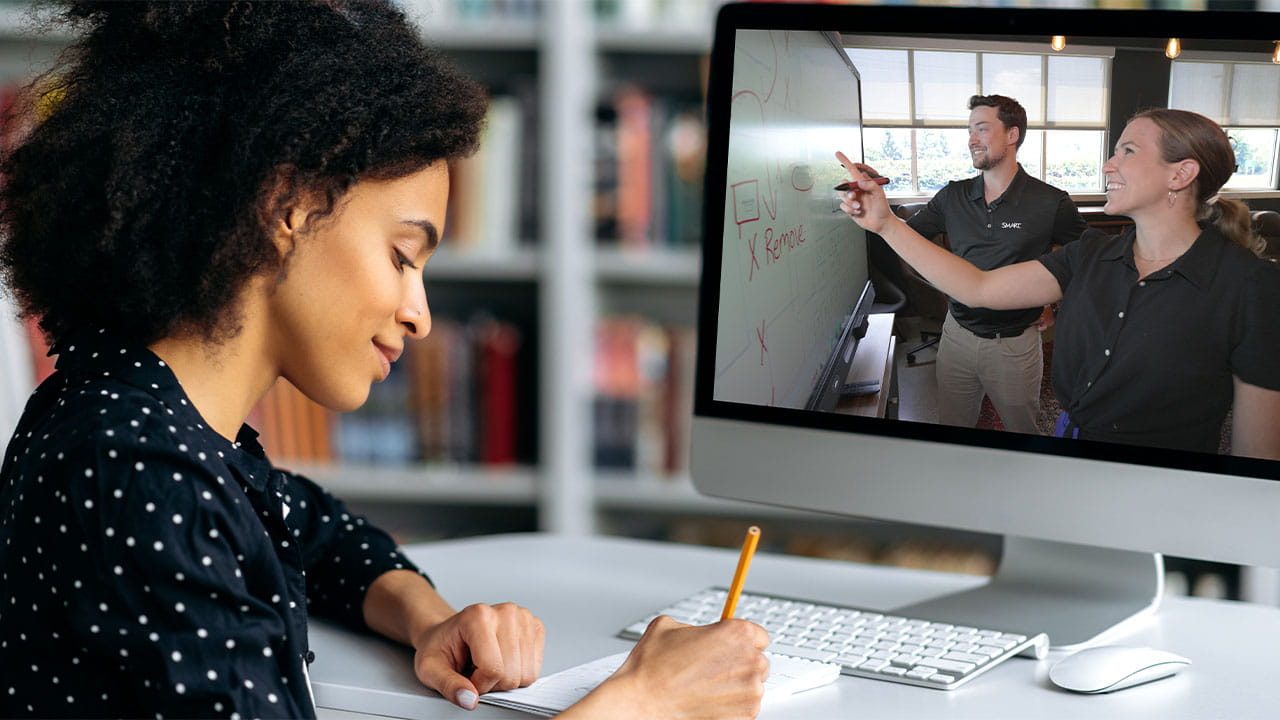 Virtual learning session with a woman observing a SMART Board product demonstration by business professionals while taking notes.